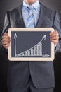 Businessman showing bargraph drawn on slate