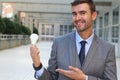 Businessman showing light bulb in office building Royalty Free Stock Photo