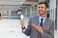 Businessman showing light bulb in office building Royalty Free Stock Photo