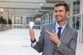 Businessman showing light bulb in office building Royalty Free Stock Photo