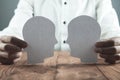 Businessman showing paper human heads on wooden desk. Business c