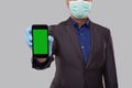 Businessman Showing Phone Wearing Medical Mask and Gloves Close Up. Indian Business Man Technology Business at Home. Phone Green Royalty Free Stock Photo