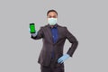 Businessman Showing Phone Wearing Medical Mask and Gloves. Indian Business Man Technology Business at Home. Phone Green Screen Royalty Free Stock Photo