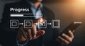 Businessman showing progress bar and checklist on virtual screen using mobile phone representing task completion Royalty Free Stock Photo
