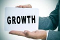 Businessman showing a signboard with the text growth