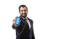 Bearded businessman with earphones showing smartphone with twitter website