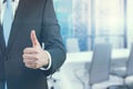 A businessman showing a thumb up sign standing in office. Panoramic Singapore view. Royalty Free Stock Photo