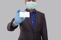 Businessman Showing Visit Card Wearing Medical Mask and Gloves Close Up Isolated. Indian Business man blank Card in Hand Royalty Free Stock Photo