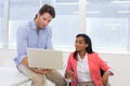 Businessman showing woman in wheelchair document on laptop Royalty Free Stock Photo