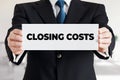 Businessman shows a banner with the message closing costs Royalty Free Stock Photo