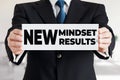 Businessman shows a banner with the message new mindset new results. Mindset change and self development in business Royalty Free Stock Photo