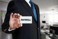 Businessman shows a business card with the word payroll. Business finance Royalty Free Stock Photo