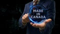 Businessman shows concept hologram Made in Canada on his hand