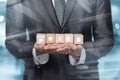 Businessman shows cubes with the inscription price on a blurred background