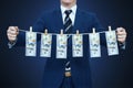 Businessman shows laundered money. Businessman holding money hanging on a rope Royalty Free Stock Photo