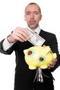 Businessman shredding dollars in a piggy bank