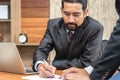 Businessman sign document in office. Business Team partners reading a document before signing contract agreement