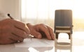 Businessman is signing a contract, extra close up of male hand putting signature, seal or stamp on foreground blurred Royalty Free Stock Photo