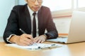 Businessman signing contract paper with pen and laptop in office desk. Royalty Free Stock Photo