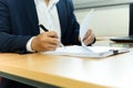 Businessman signing contract paper with pen in office desk. Royalty Free Stock Photo