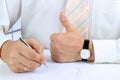 Businessman signing a document and showing OK sign with his thu Royalty Free Stock Photo