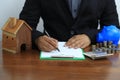 Businessman signing documents with model house, New home and real estate concept Royalty Free Stock Photo