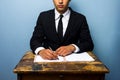 Businessman signing documents at old wooden desk Royalty Free Stock Photo