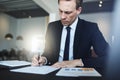 Businessman signing documents while sitting at his office desk Royalty Free Stock Photo