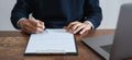 Businessman signing financial contract and hand holding pen putting signature after reaching agreement.