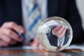 Businessman signing papers in front of glass ball Royalty Free Stock Photo