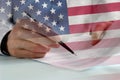 Businessman signing papers with US flag overlay Royalty Free Stock Photo