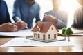 Businessman signing real estate purchase contract behind house architectural model. Royalty Free Stock Photo