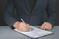 Businessman signs contract. Holding pen in hand. Businessman signing contract at table. Signing legal document. dark background Royalty Free Stock Photo
