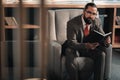 Businessman sitting in armchair feeling involved in reading Royalty Free Stock Photo