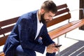 Businessman sitting on bench with mobile phone Royalty Free Stock Photo