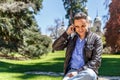 A businessman sitting on a bench is talking from his mobile phone Royalty Free Stock Photo