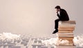 Businessman sitting on books in labirynth