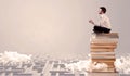 Businessman sitting on books in labirynth