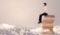 Businessman sitting on books in labirynth