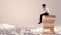 Businessman sitting on books in labirynth