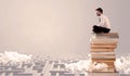 Businessman sitting on books in labirynth