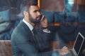 Businessman sitting in a business center restaurant with laptop phone call Royalty Free Stock Photo