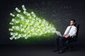 Businessman sitting in chair holding laptop with dollar bills co Royalty Free Stock Photo