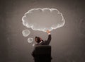 Businessman sitting with cloud thought above his head