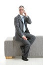 Businessman sitting on couch talking on phone Royalty Free Stock Photo