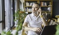 Businessman sitting at desk in bright office, talking on mobile phone Royalty Free Stock Photo