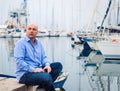 Businessman sitting by expensive sailing boats and yachts in a c Royalty Free Stock Photo