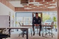 A businessman sitting on his desk, taking a moment to rest and unwind from a demanding workday, displaying a sense of