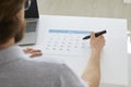 Businessman sitting at his desk and using a calendar to organize his business schedule Royalty Free Stock Photo