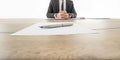 Businessman sitting at his wooden office desk with contract infr